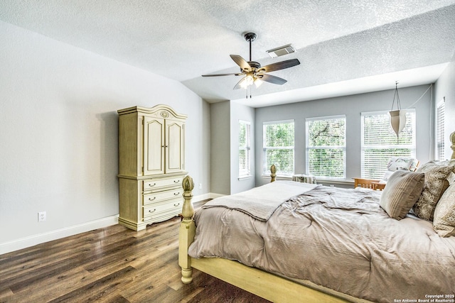 bedroom featuring baseboards, dark wood-style flooring, vaulted ceiling, and visible vents