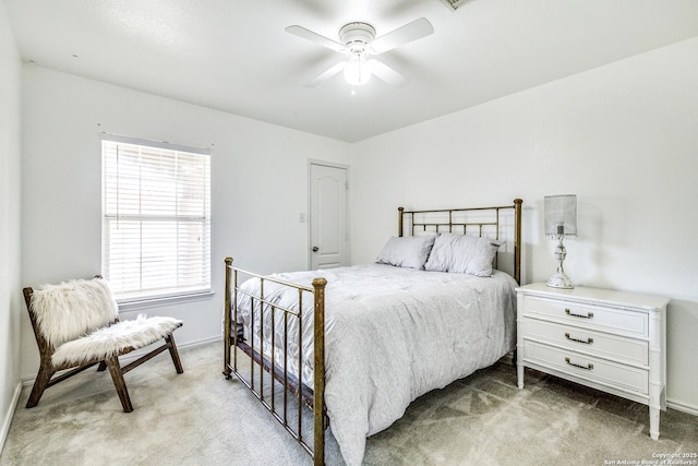 bedroom featuring light carpet, a ceiling fan, and baseboards