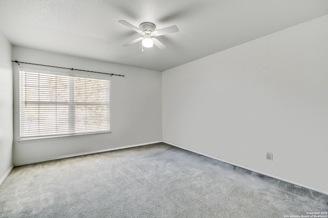 carpeted empty room with ceiling fan and baseboards
