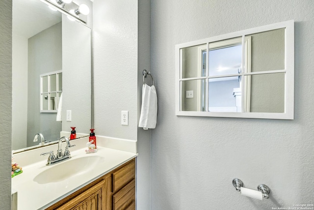 bathroom featuring a textured wall and vanity