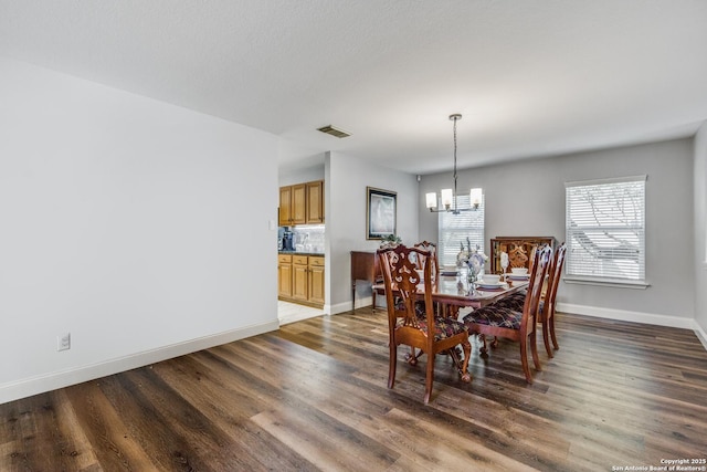 dining area with visible vents, baseboards, a chandelier, and dark wood-style flooring