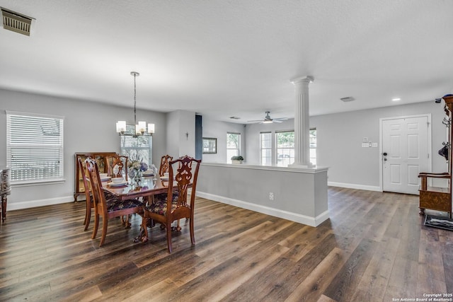dining area featuring ornate columns, visible vents, dark wood-type flooring, baseboards, and ceiling fan with notable chandelier