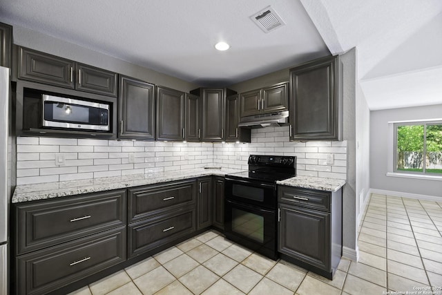 9400 Woodland Hls, San Antonio, TX 78250 - kitchen featuring light tile patterned floors, stainless steel microwave, range with two ovens, under cabinet range hood, and visible vents