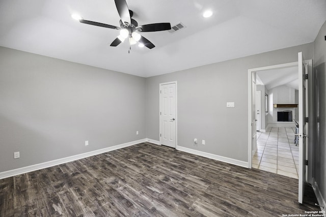 9400 Woodland Hls, San Antonio, TX 78250 - unfurnished bedroom with dark wood-style floors, vaulted ceiling, baseboards, visible vents, and a ceiling fan