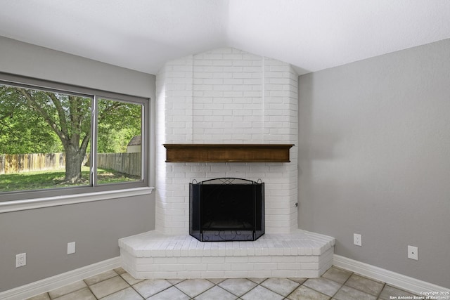 9400 Woodland Hls, San Antonio, TX 78250 - unfurnished living room with tile patterned flooring, baseboards, a brick fireplace, and vaulted ceiling