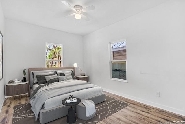 2201 San Fernando, San Antonio, TX 78207 - bedroom featuring wood finished floors, a ceiling fan, baseboards, and multiple windows