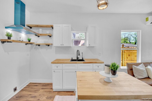 2201 San Fernando, San Antonio, TX 78207 - kitchen with white cabinets, light wood-style floors, wooden counters, and a sink