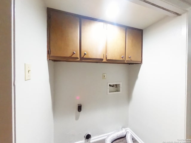 laundry room featuring electric dryer hookup, baseboards, hookup for a washing machine, and cabinet space