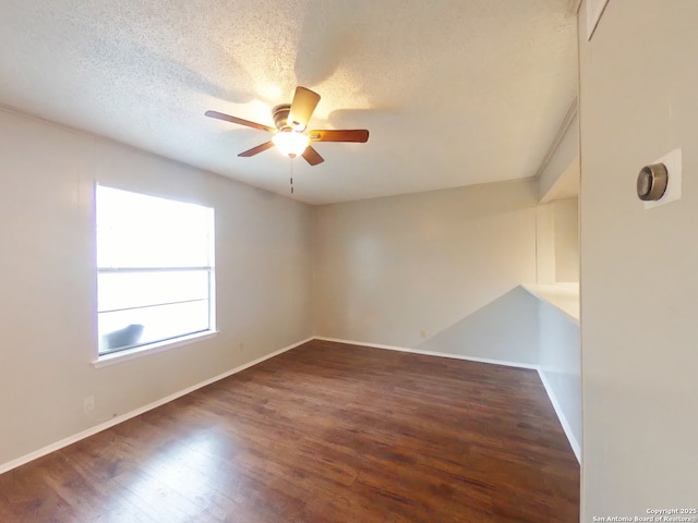 unfurnished room featuring baseboards, wood finished floors, a textured ceiling, and ceiling fan