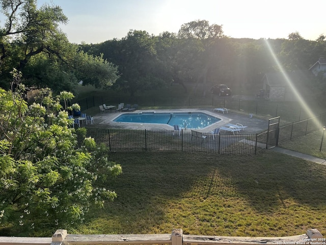 community pool featuring a patio area, fence, and a yard
