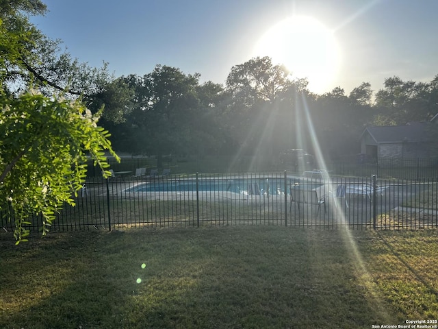 view of swimming pool with a lawn, fence, and a fenced in pool