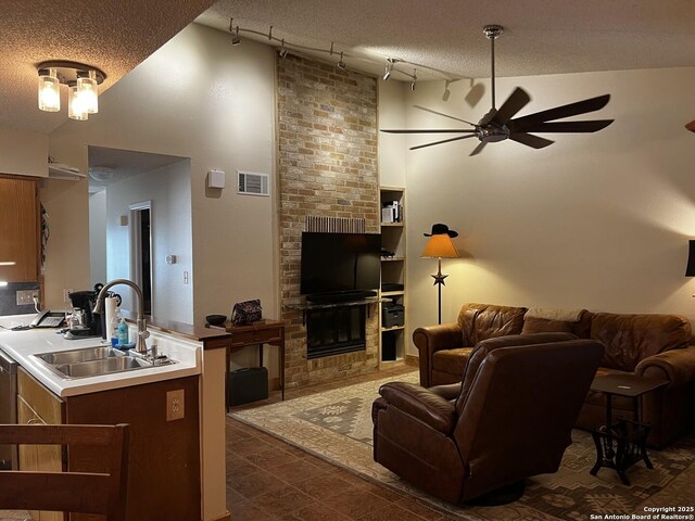 living area featuring high vaulted ceiling, rail lighting, a ceiling fan, and visible vents
