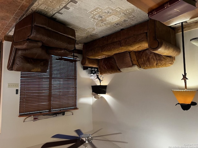 unfurnished living room featuring a ceiling fan and an ornate ceiling
