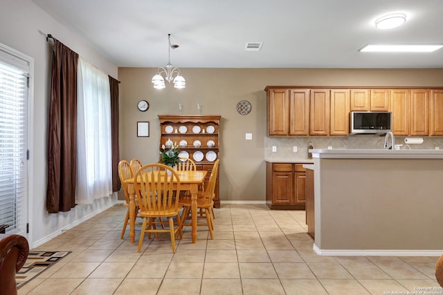 711 Point Spgs, San Antonio, TX 78253 - kitchen with stainless steel microwave, a chandelier, decorative backsplash, and light countertops