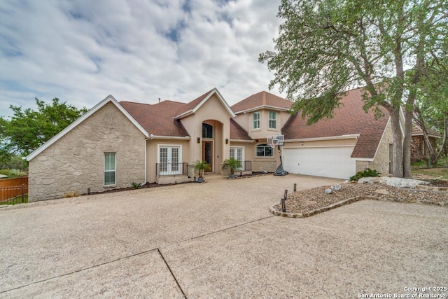19111 Nature Oaks, San Antonio, TX 78258 - view of front of home with french doors, driveway, stone siding, a garage, and stucco siding
