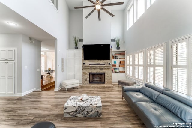 19111 Nature Oaks, San Antonio, TX 78258 - living area with wood finished floors, a towering ceiling, a stone fireplace, and ceiling fan