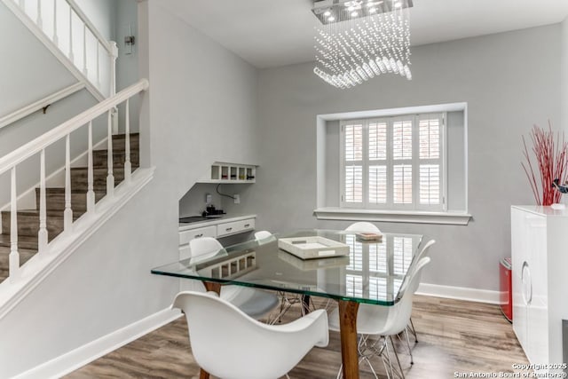 19111 Nature Oaks, San Antonio, TX 78258 - dining area with baseboards, wood finished floors, stairs, and an inviting chandelier
