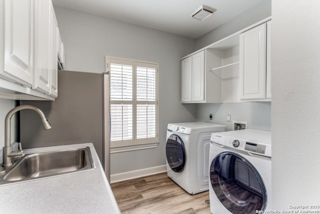 19111 Nature Oaks, San Antonio, TX 78258 - clothes washing area with washer and clothes dryer, cabinet space, a sink, and plenty of natural light