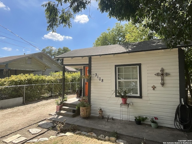 3108 Vera Cruz, San Antonio, TX 78207 - view of front of house featuring fence, an outdoor structure, and roof with shingles
