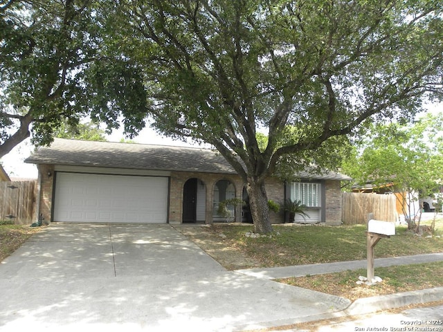 ranch-style house with a garage, fence, concrete driveway, and brick siding