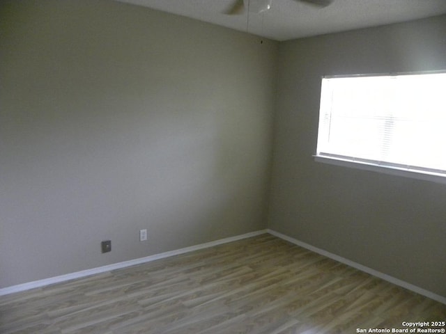 unfurnished room featuring baseboards, a ceiling fan, and wood finished floors