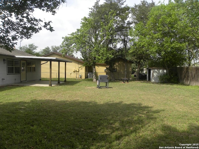 view of yard featuring fence, an outbuilding, a patio area, and a shed