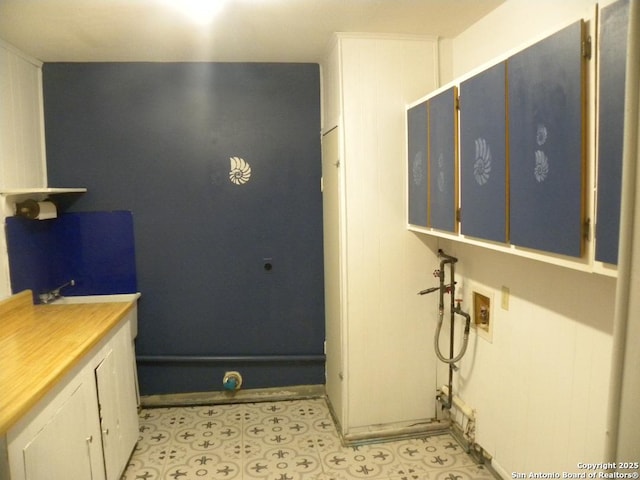 interior space with light floors, washer hookup, and cabinet space