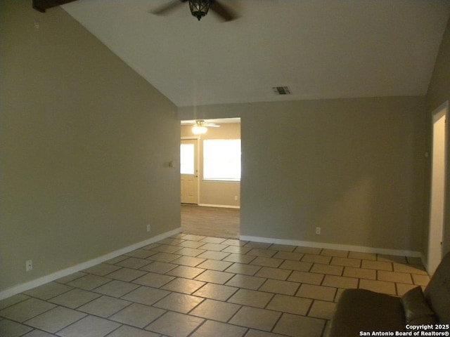 tiled spare room featuring a ceiling fan, baseboards, visible vents, and lofted ceiling
