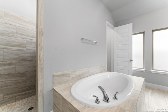 bathroom featuring a tile shower and a bath