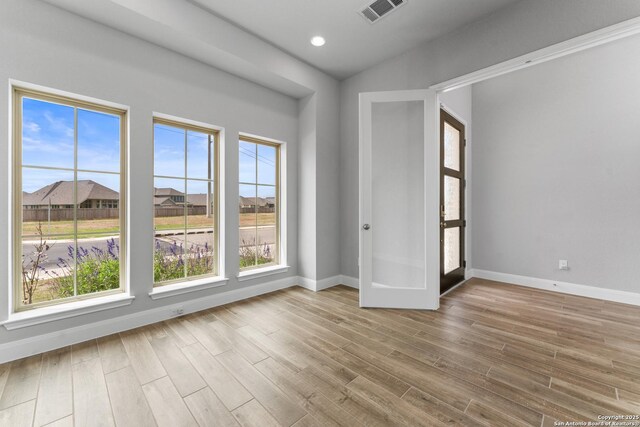 unfurnished room featuring baseboards, wood finished floors, visible vents, and recessed lighting