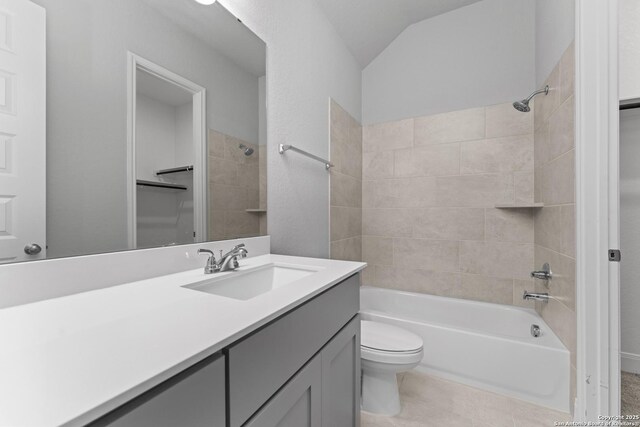 bathroom featuring tile patterned floors, vaulted ceiling, toilet, vanity, and tub / shower combination