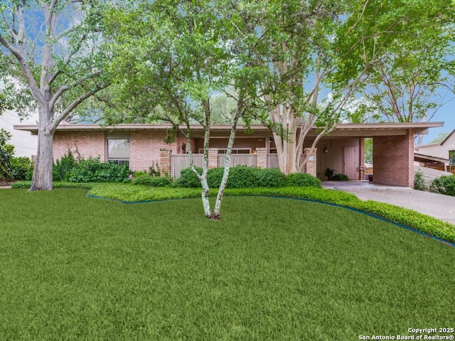single story home with a front lawn, brick siding, a carport, and aphalt driveway
