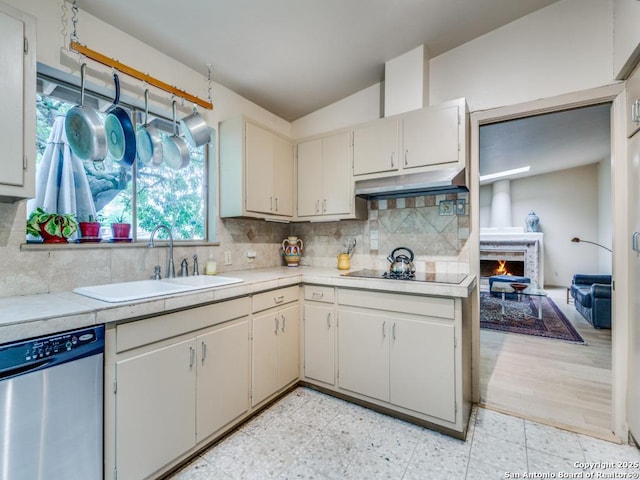 kitchen featuring dishwasher, decorative backsplash, under cabinet range hood, and a sink