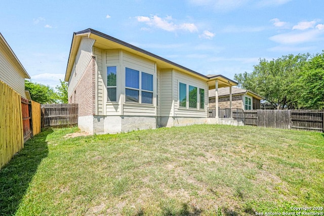 back of property featuring a yard and a fenced backyard