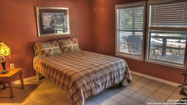bedroom with baseboards and tile patterned floors