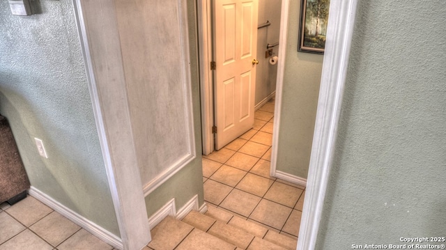 hall with baseboards and light tile patterned floors