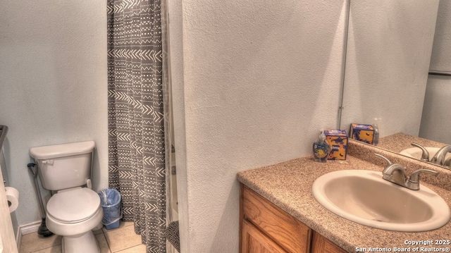 full bath featuring toilet, a textured wall, vanity, and tile patterned floors