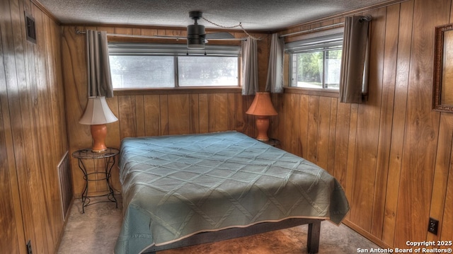 bedroom with wooden walls and a textured ceiling