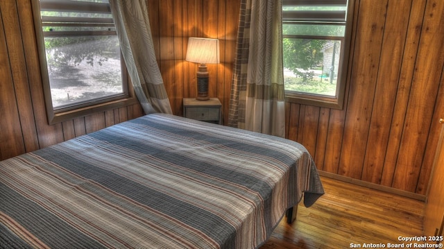 bedroom with wooden walls and wood finished floors