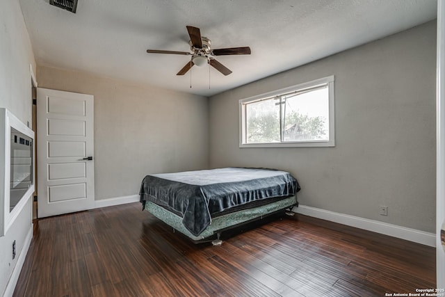 bedroom featuring visible vents, baseboards, and dark wood-style floors