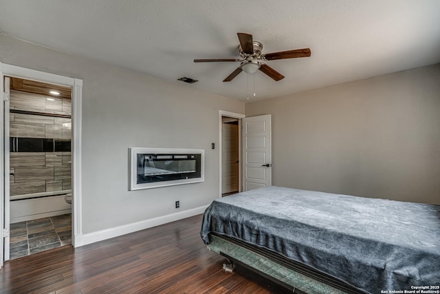 bedroom featuring wood finished floors, visible vents, a ceiling fan, connected bathroom, and baseboards