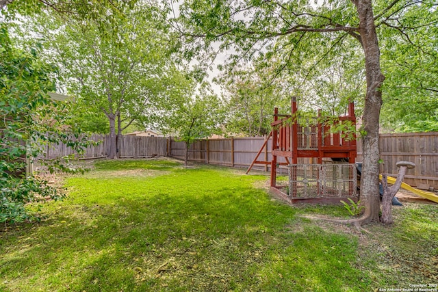 view of yard featuring a fenced backyard and a playground