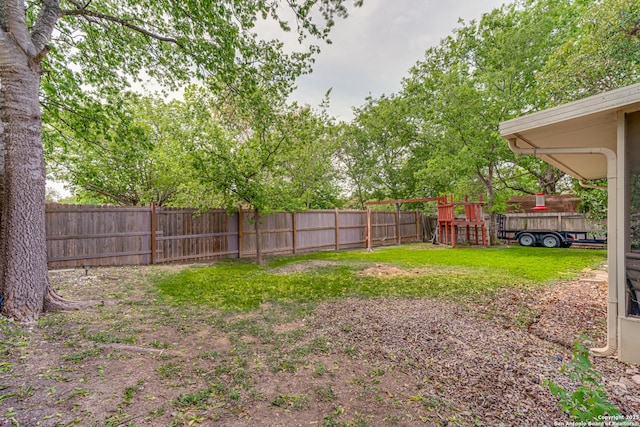 view of yard featuring a fenced backyard and a playground
