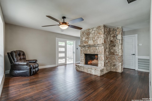 unfurnished living room featuring wood finished floors, baseboards, a fireplace, and ceiling fan