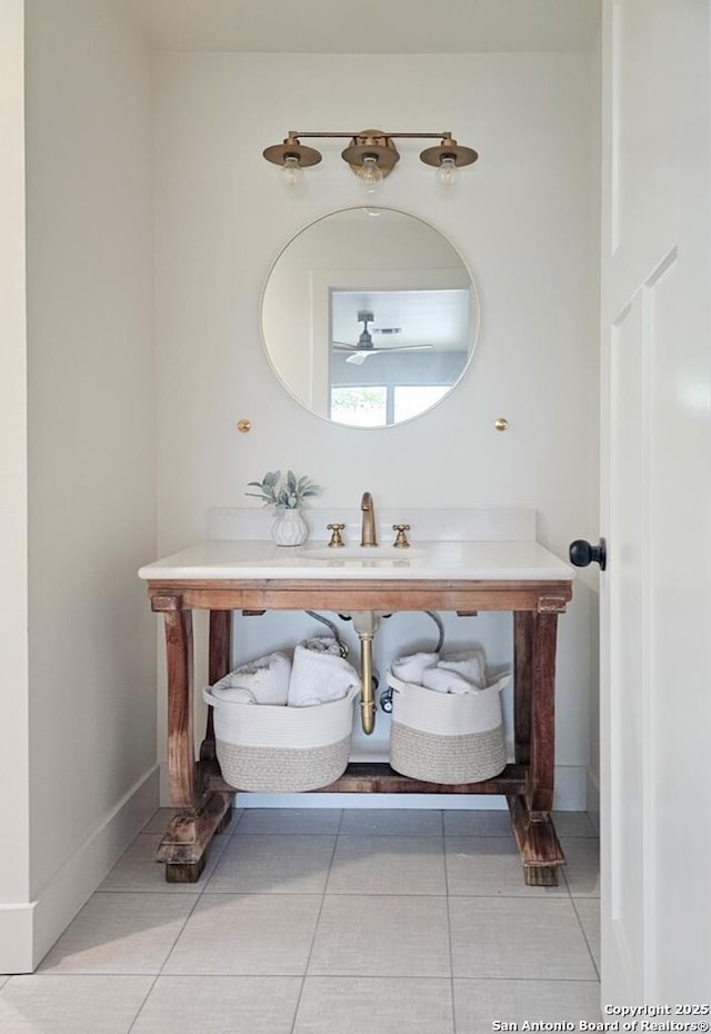 bathroom with baseboards, tile patterned floors, and a sink