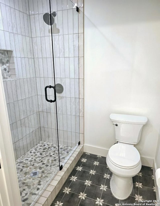 full bath with a shower stall, baseboards, toilet, and tile patterned flooring