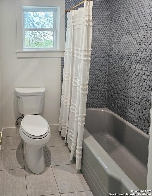 bathroom with toilet, tile patterned flooring, and baseboards