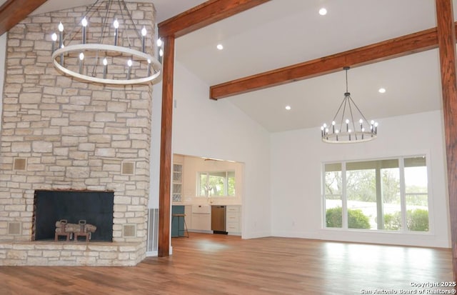 unfurnished living room with beamed ceiling, wood finished floors, and a notable chandelier
