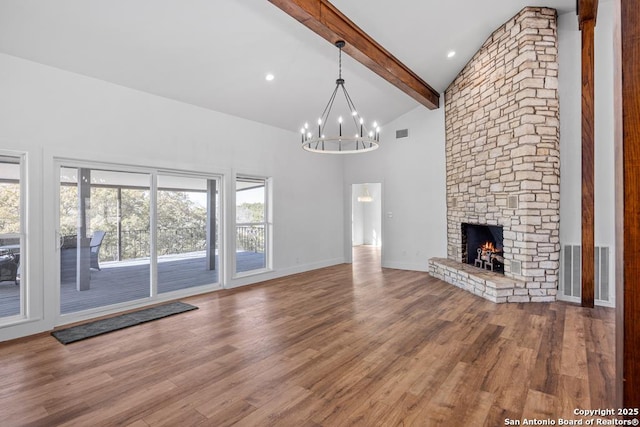 unfurnished living room with wood finished floors, visible vents, beam ceiling, and a notable chandelier