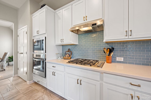 kitchen featuring backsplash, stainless steel appliances, under cabinet range hood, and white cabinetry